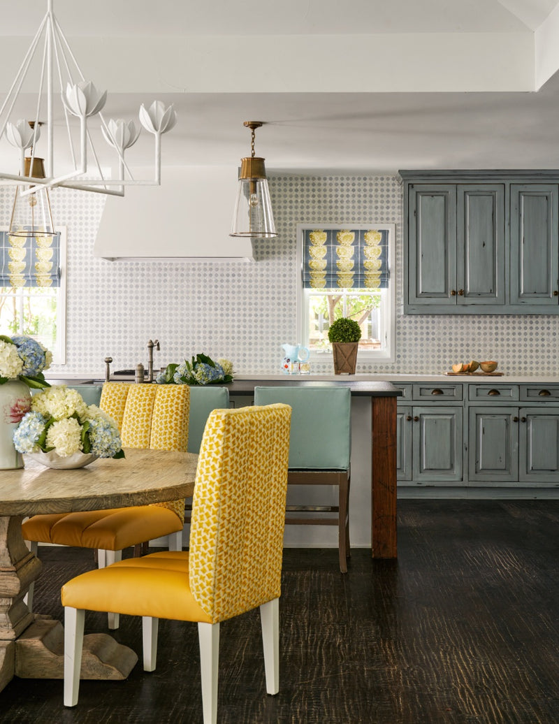 View into kitchen and dining area with yellow upholstered dining chairs
