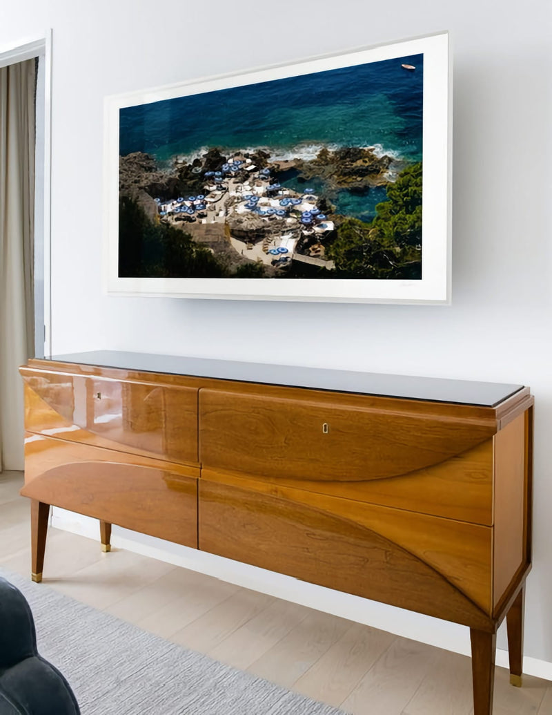 Photo framed and hanging above polished wood cabinet