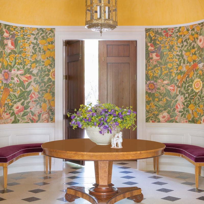 Entry area table with floral wallcovering and yellow ceiling