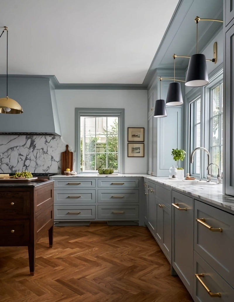 View into kitchen with light blue cabinets and white marble top