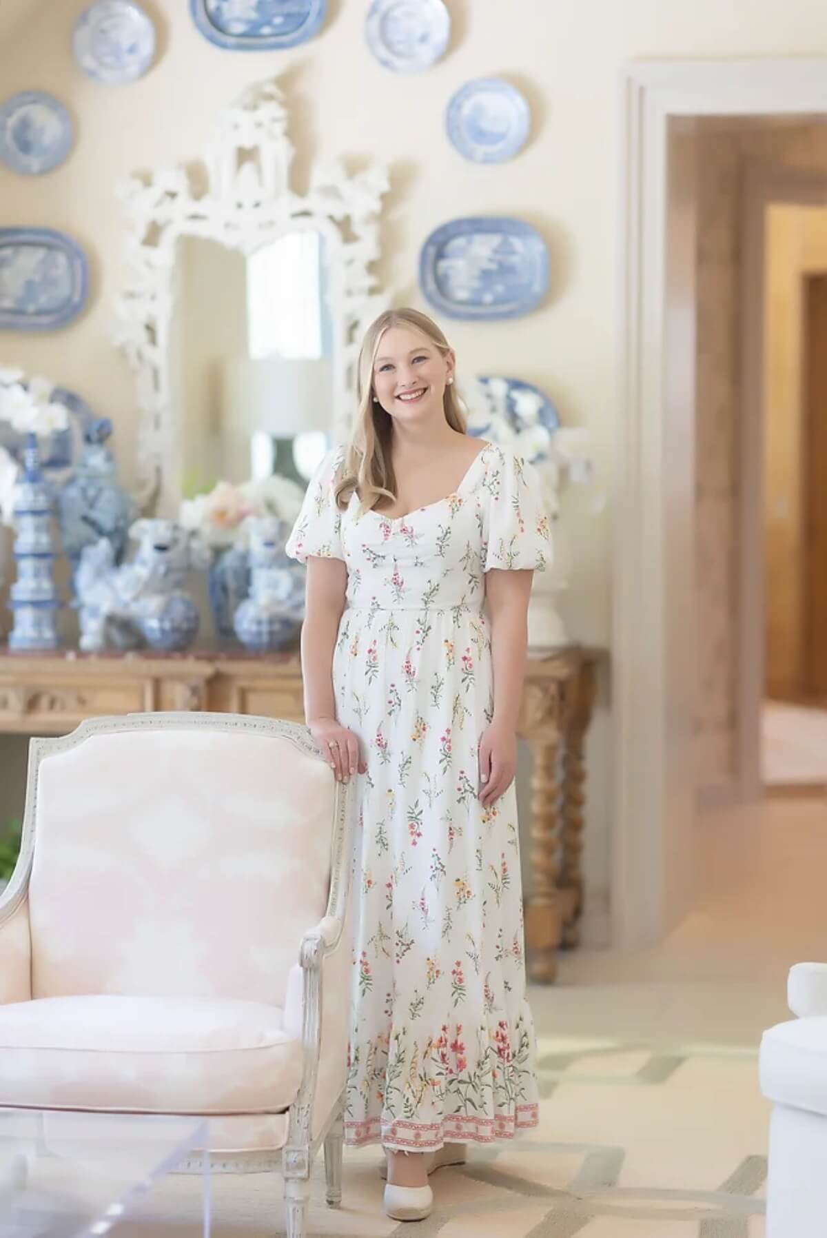 Photo of Anna Mazzocchi in a floral dress next to lounge chair