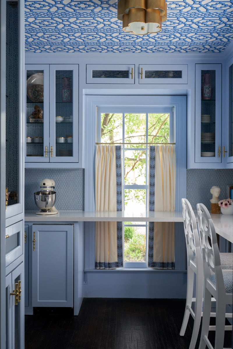 Blue cabinets in kitchen with blue and white tiled ceiling