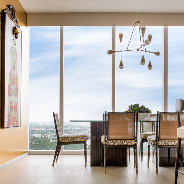 View of large windows overlooking cityscape with dining area in front.