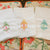 Three white tea towels with initials A, B, C