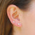 Two diamond earrings on a woman's ear