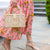Zoomed in shot of a woman holding a Rattan top handle rectangular clutch